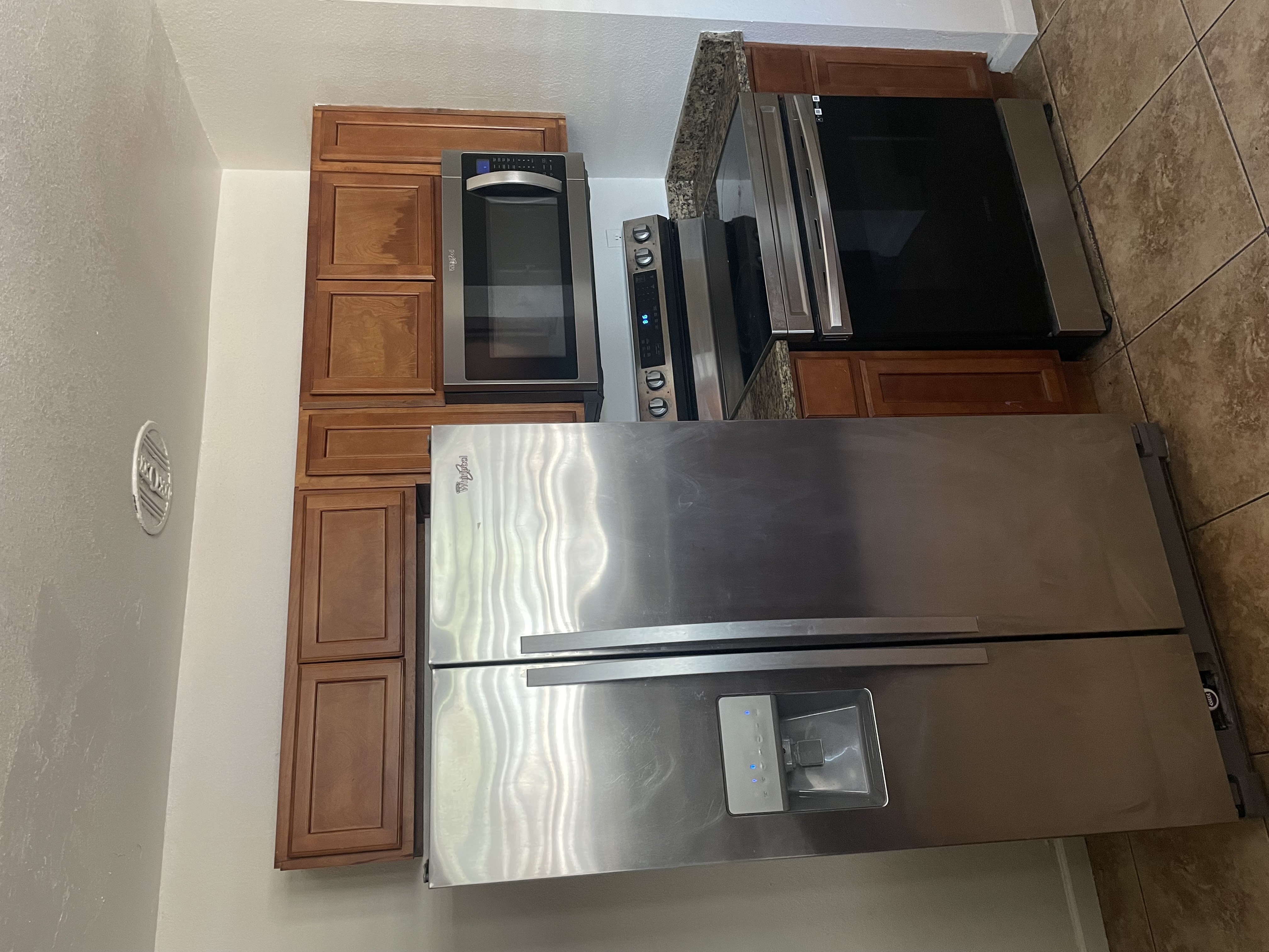 Kitchen with wood cabinets, a fridge, an oven range, and a microwave.